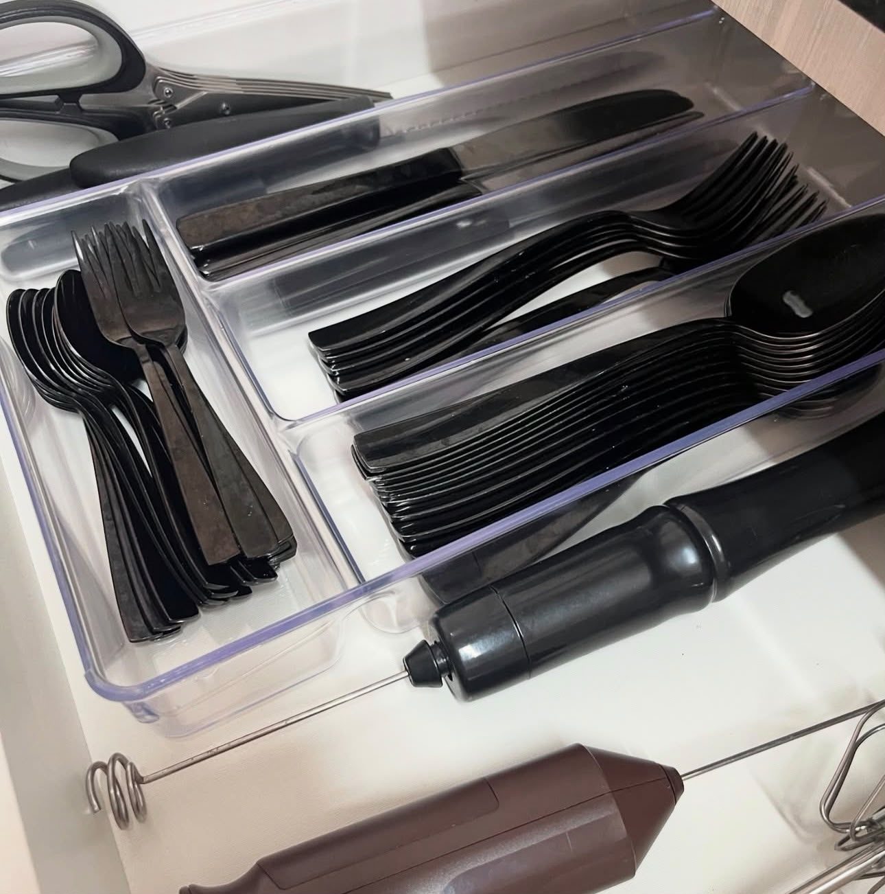 Gaveta de talheres organizada por divisórias, com utensílios separados por categoria